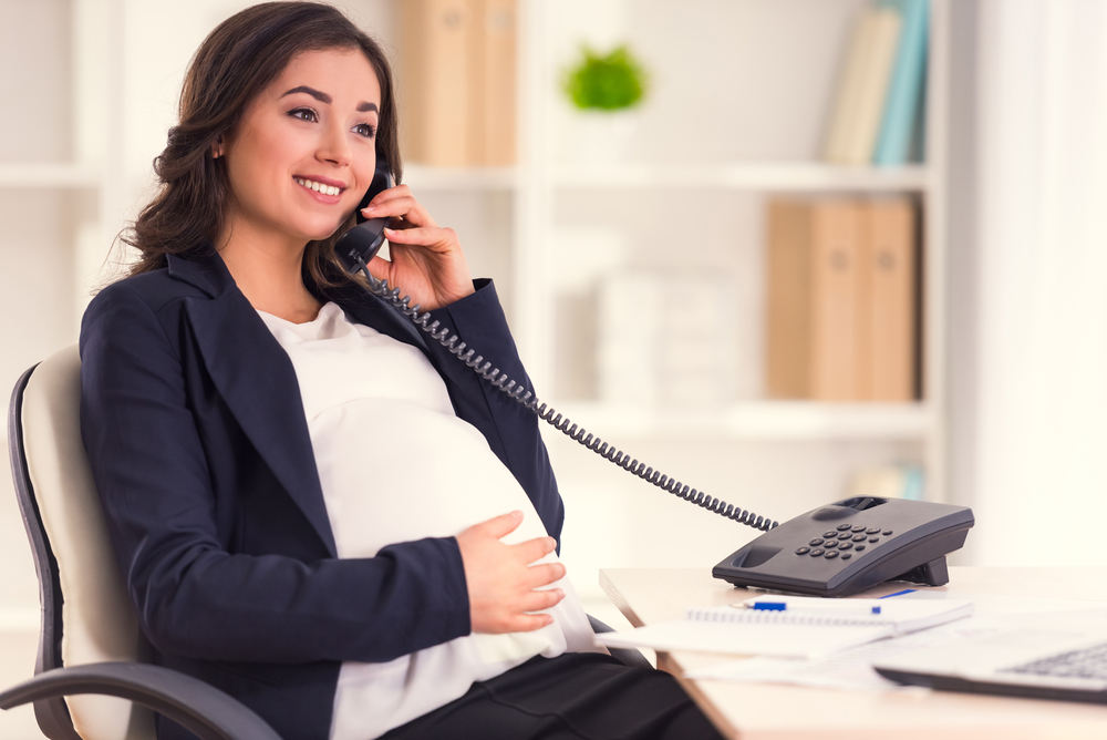 Pregnant woman on the phone at work
